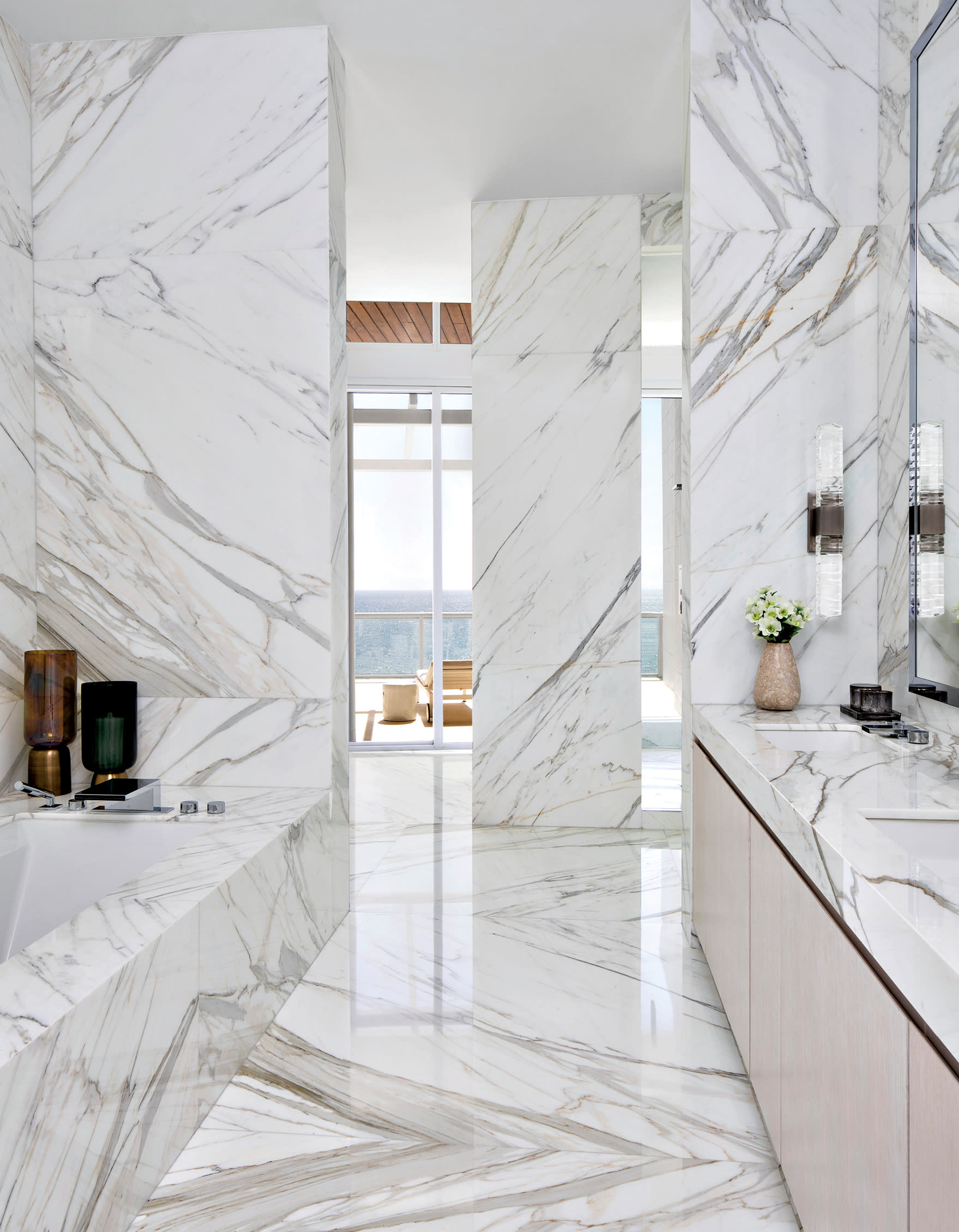 minimalist bathroom covered in slabs of white Calacatta Gold marble