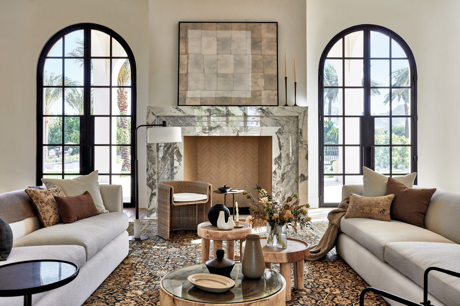 living room with twin white sofas, marble fireplace and steel-and-glass arched doors