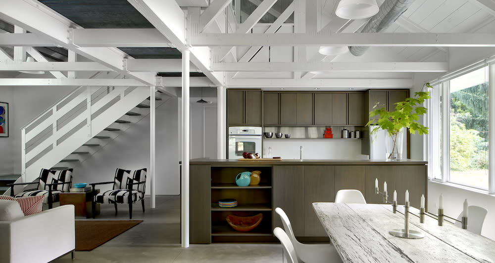 Open living space with exposed wood trusses and polished concrete floors