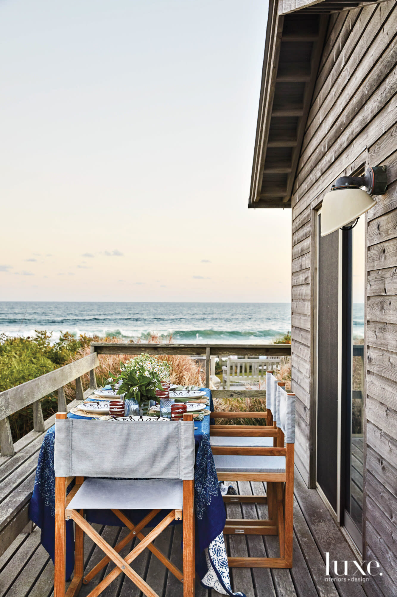 An ocean view lies beyond a set table in the Hamptons