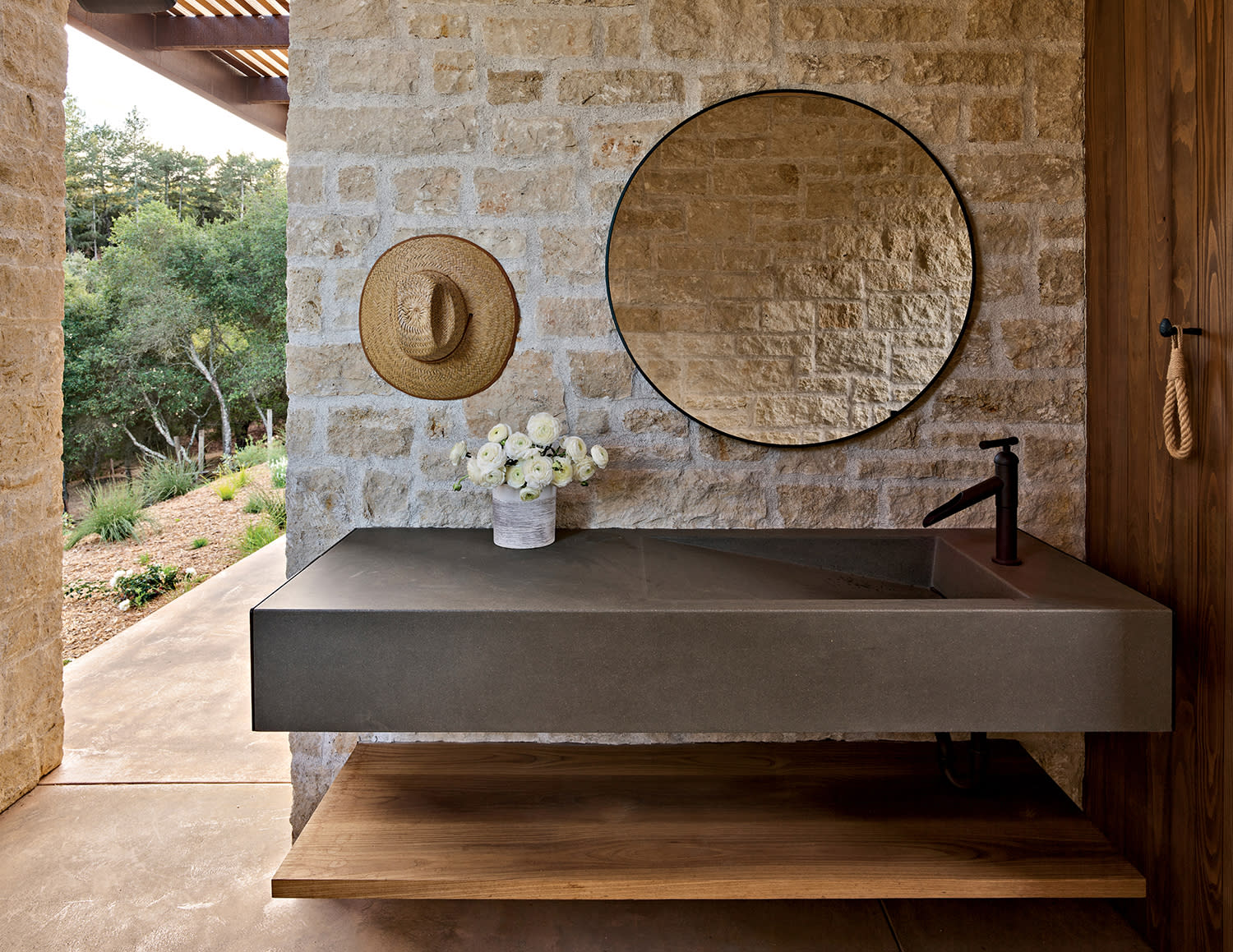 limestone walled open-air bathroom of a pool house