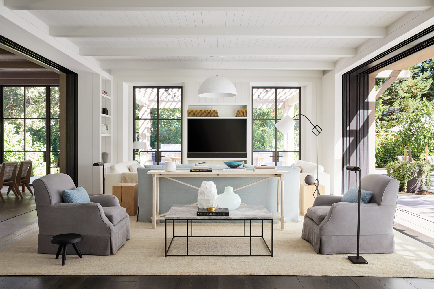 multi-seating family room with coffee tables, armchairs and floor lamp