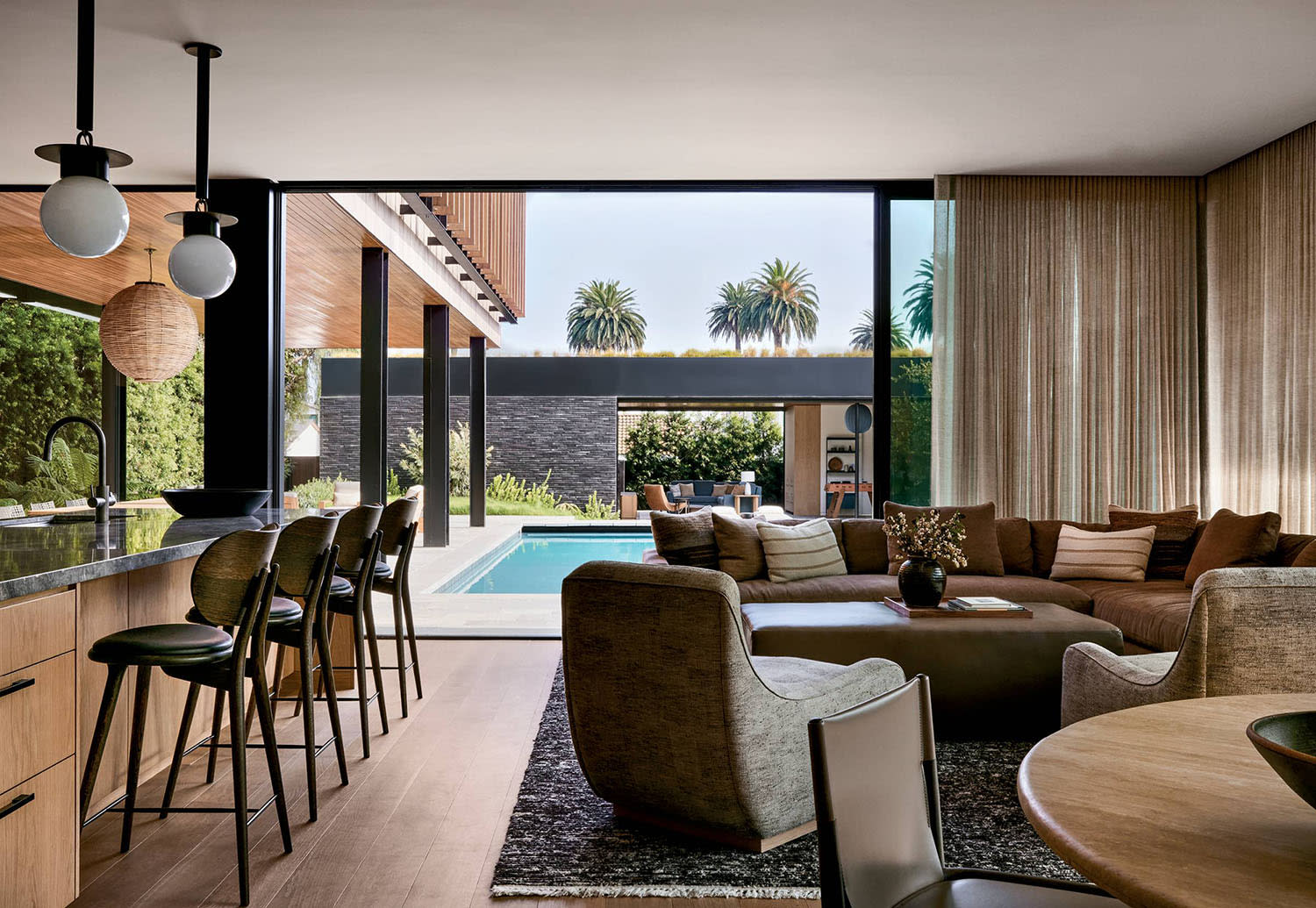 contemporary great room with views of a pool outside