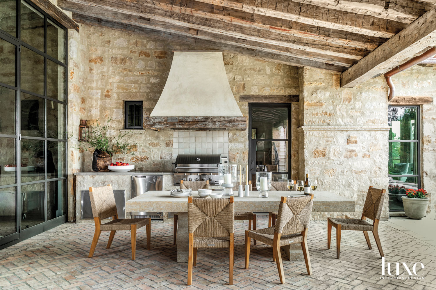 monochromatic outdoor porch with large dining area and outdoor kitchen