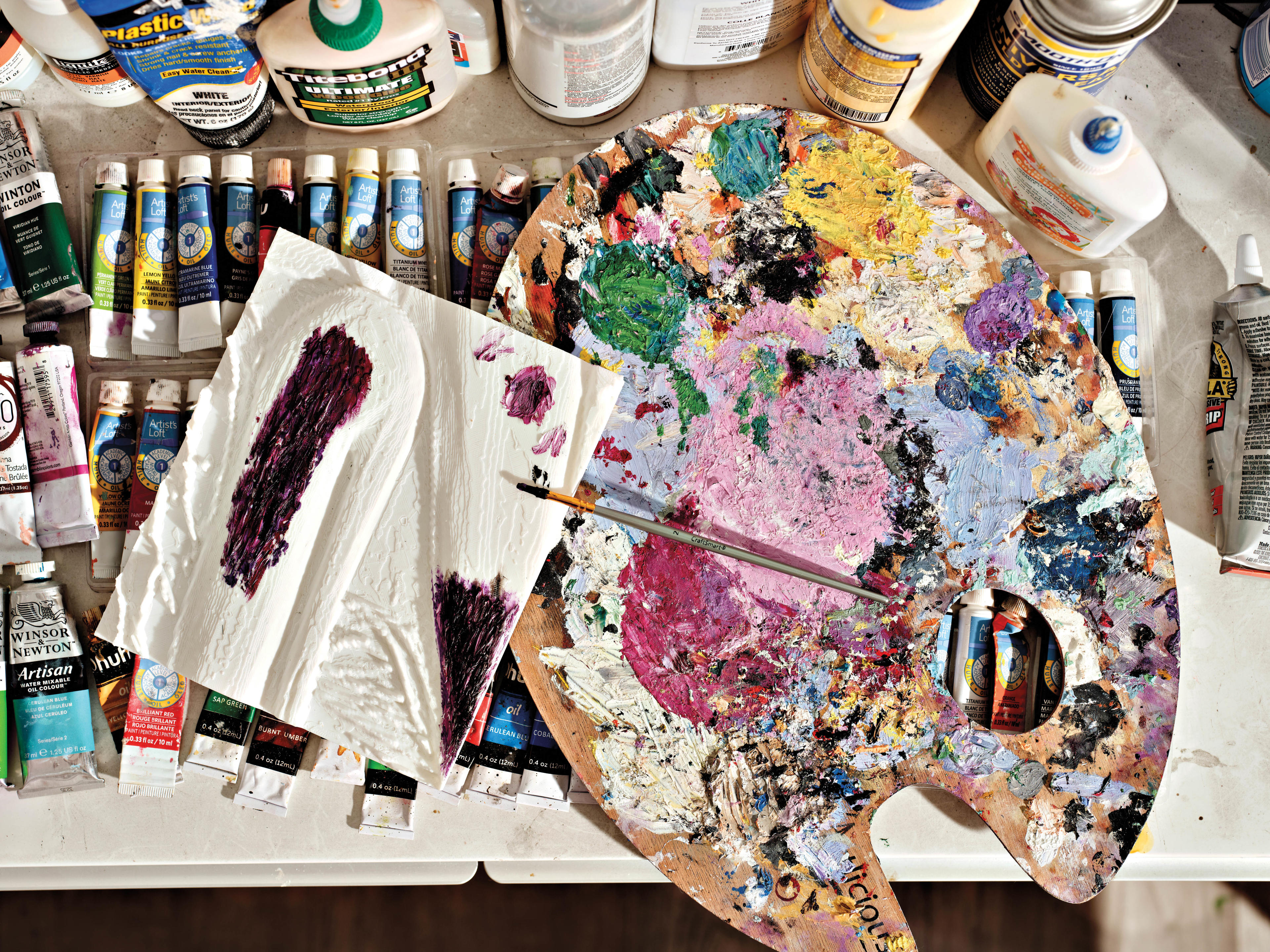 paint palette and paints spread out on a desk