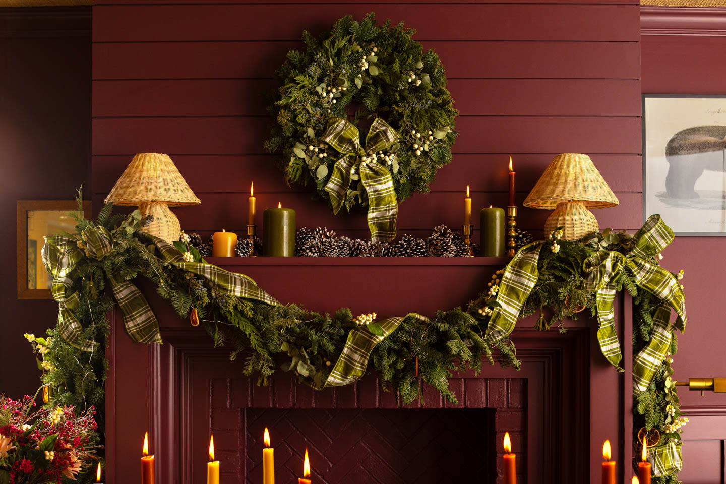 red walls and a matching fireplace covered by a holiday garland