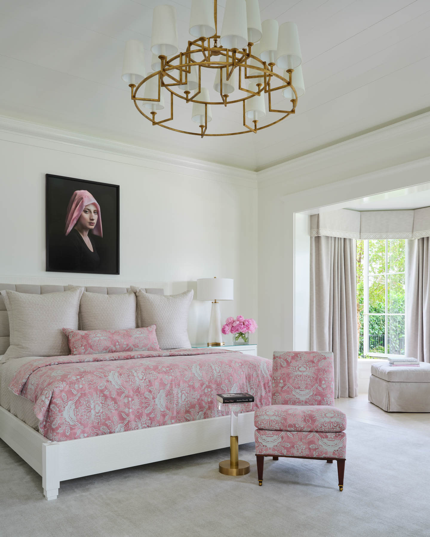 romantic bedroom with pink linens, a chandelier and a white modern lamp