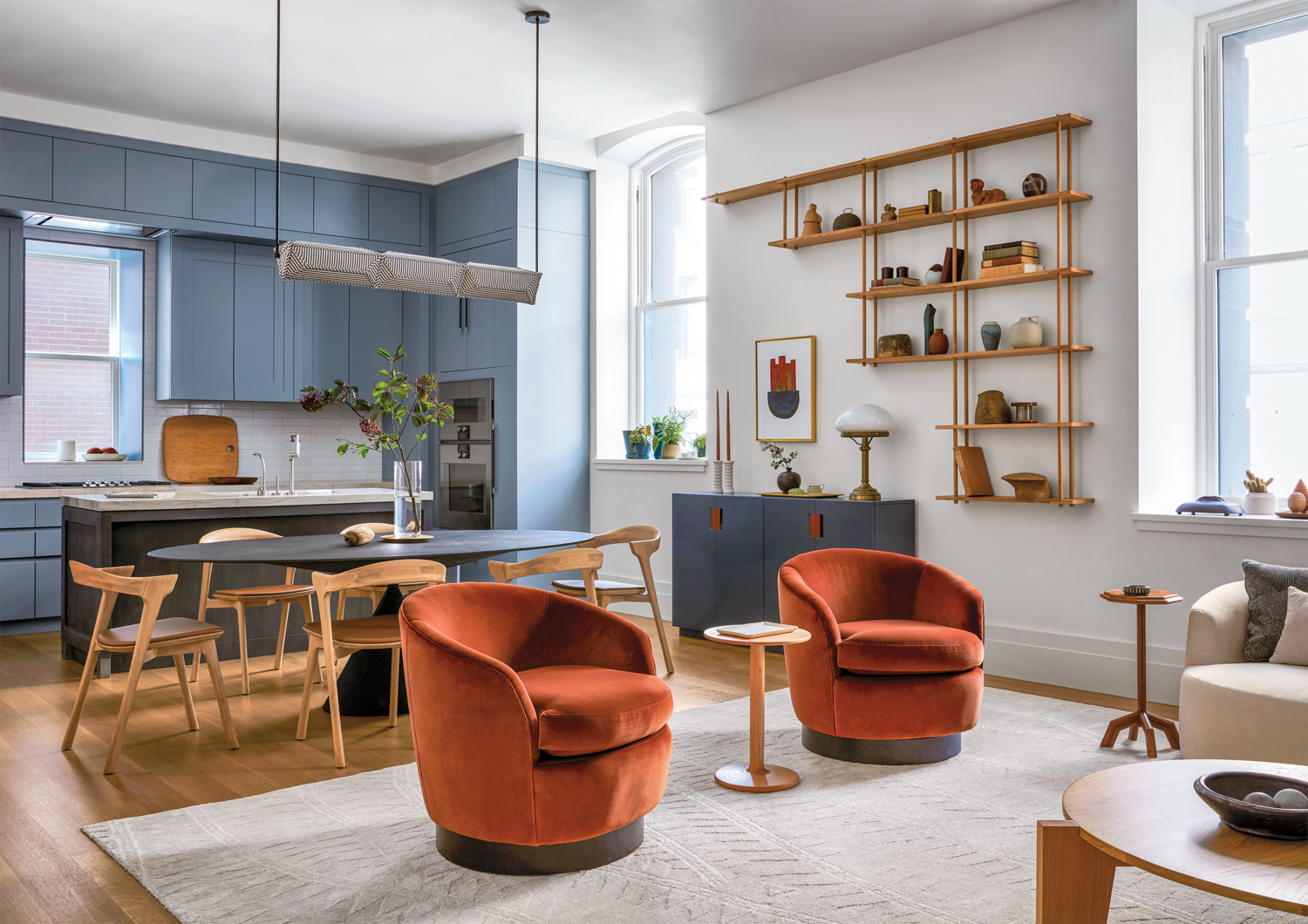 powder blue kitchen cabinets and midcentury dining table with rust-colored swivel chairs