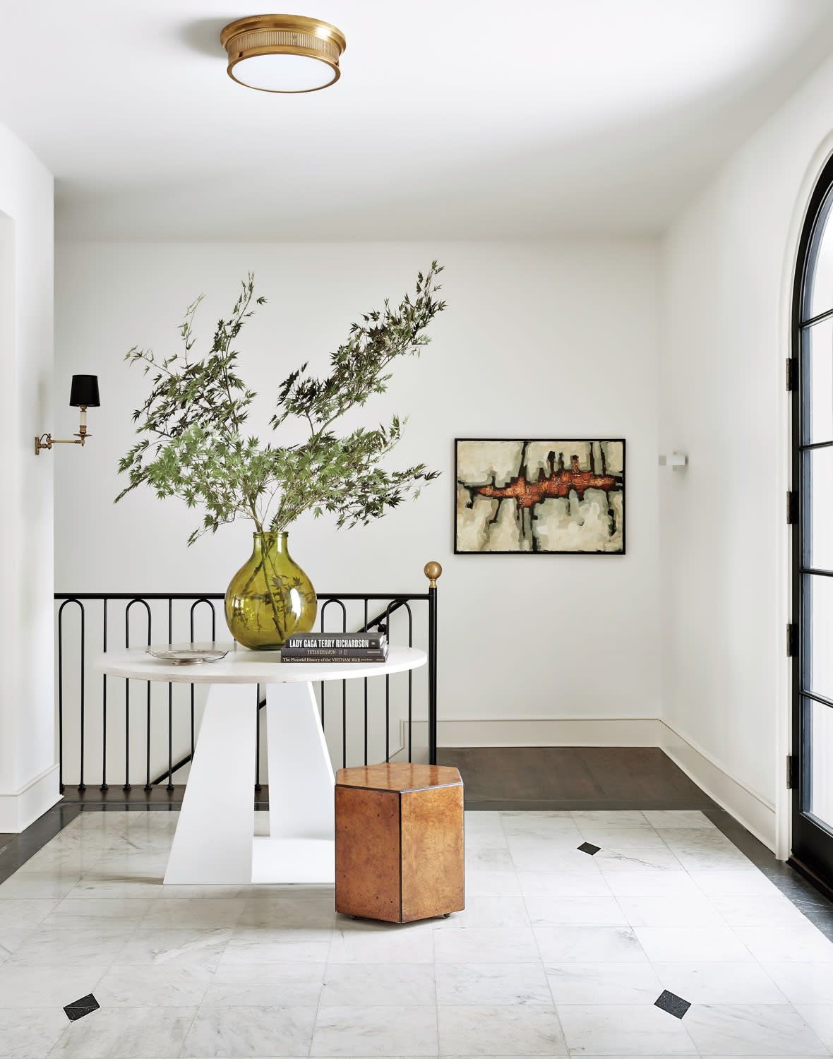 White entryway with round white table and hexagonal stool