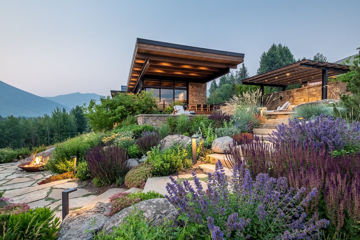 An elegant house featuring a fire pit and breathtaking mountain scenery.