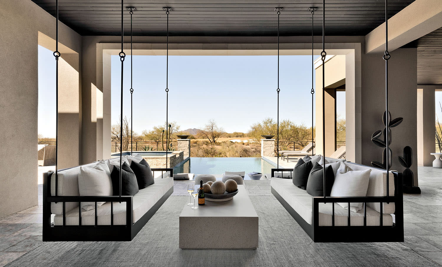 outdoor area of an Arizona home with floating iron benches on either side of a coffee table