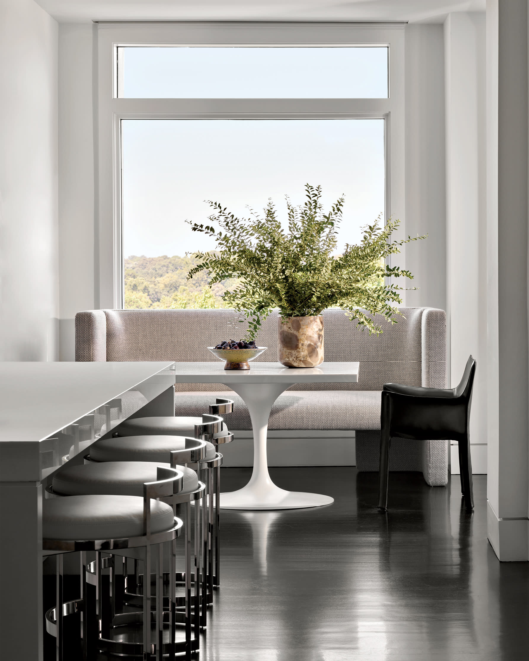 contemporary kitchen with a dark marble island and a white dining nook