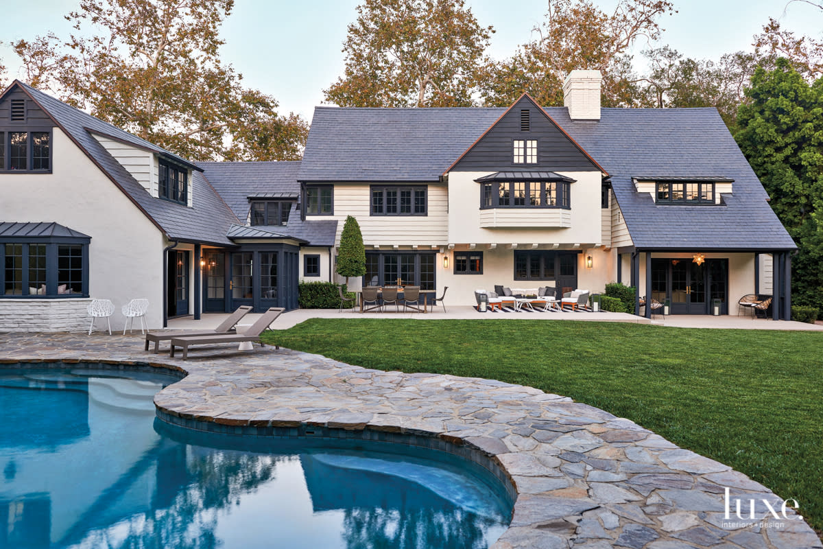 exterior of the back of the home and backyard with two sitting areas