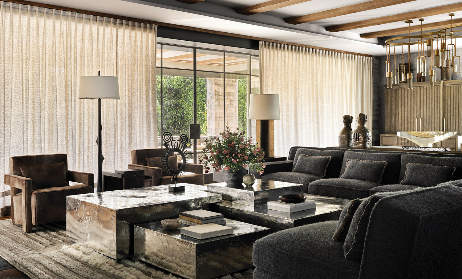 contemporary family room with sheer white drapes and a dark grey sectional