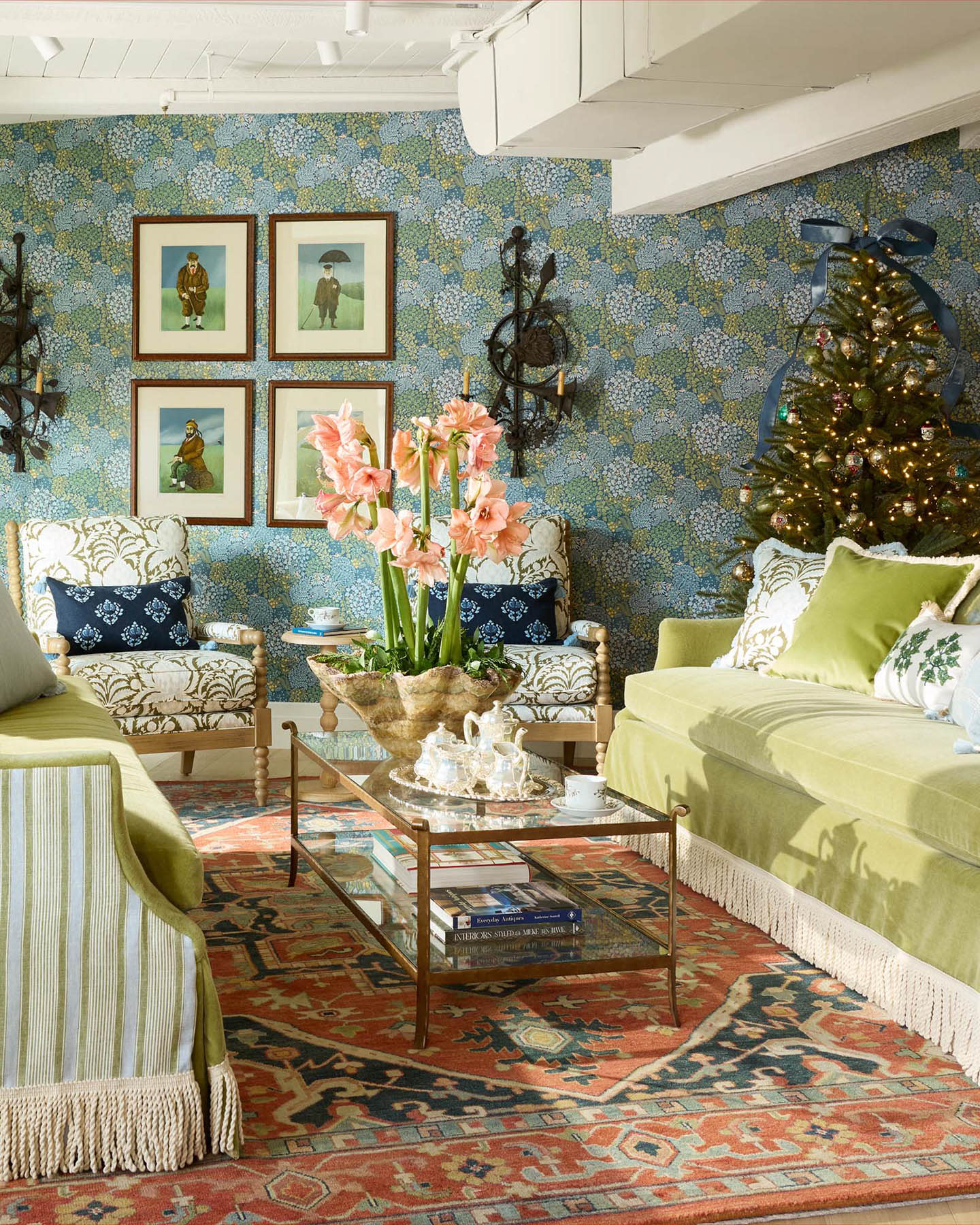 blue-green floral wallpaper surrounding two green sofas in a Christmas-themed room