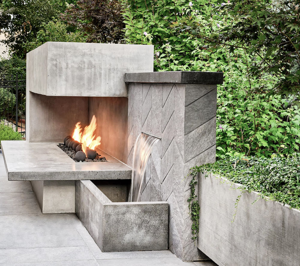 A garden with a concrete fire pit as the focal point.