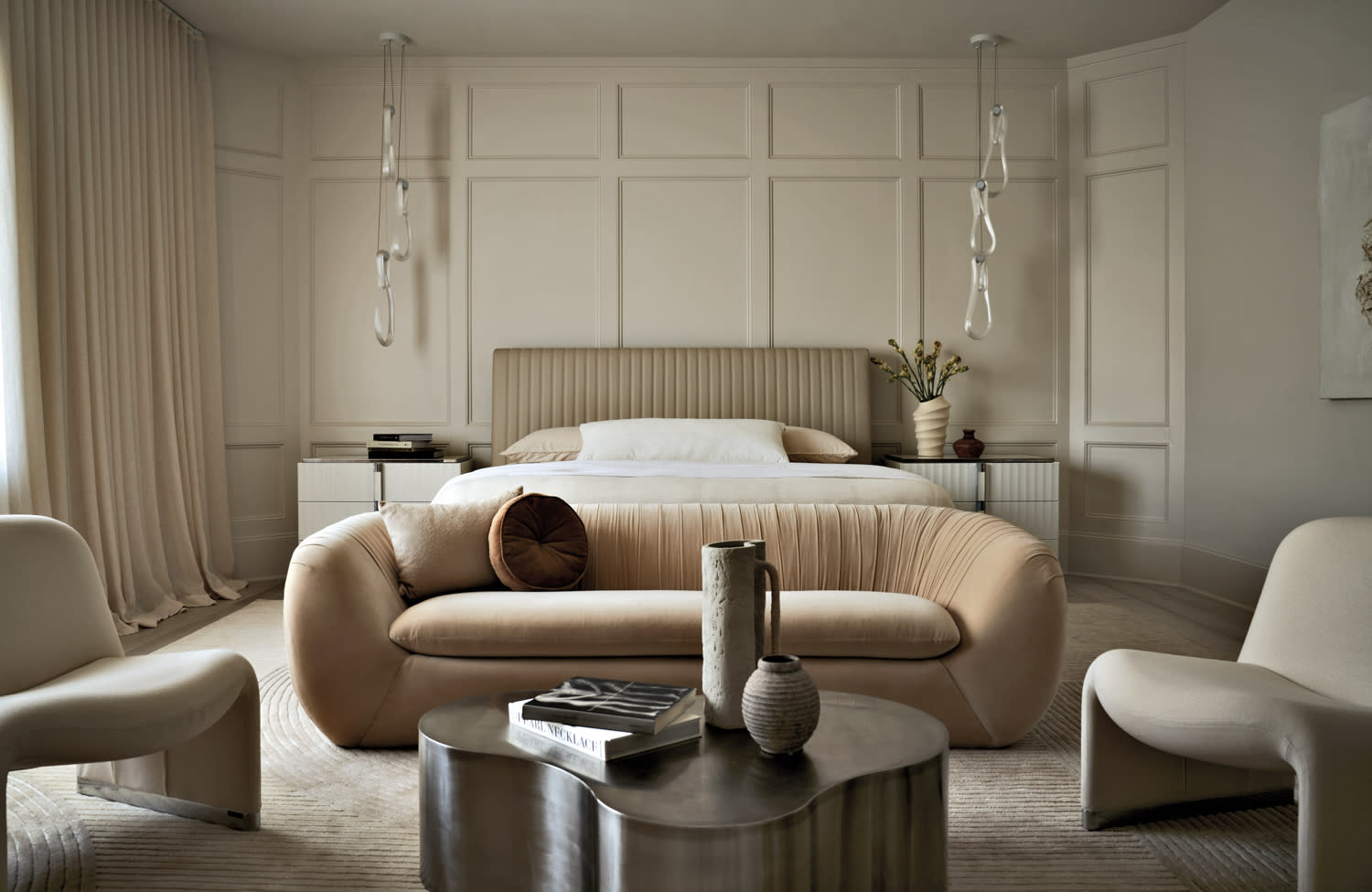 monochrome beige bedroom with a cozy seating area in front of the bed