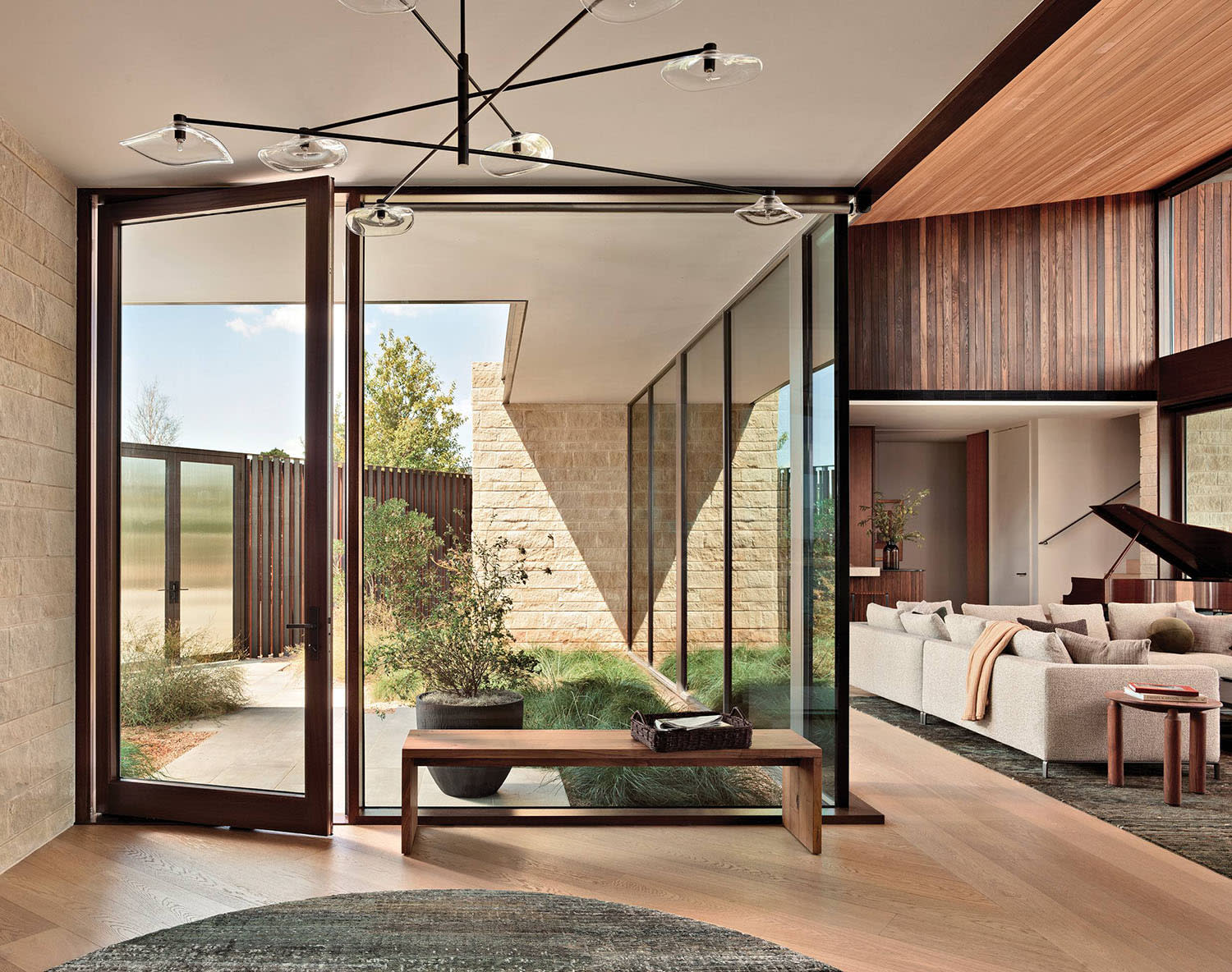glass-walled entry and a pivot door make up the foyer of an Austin home