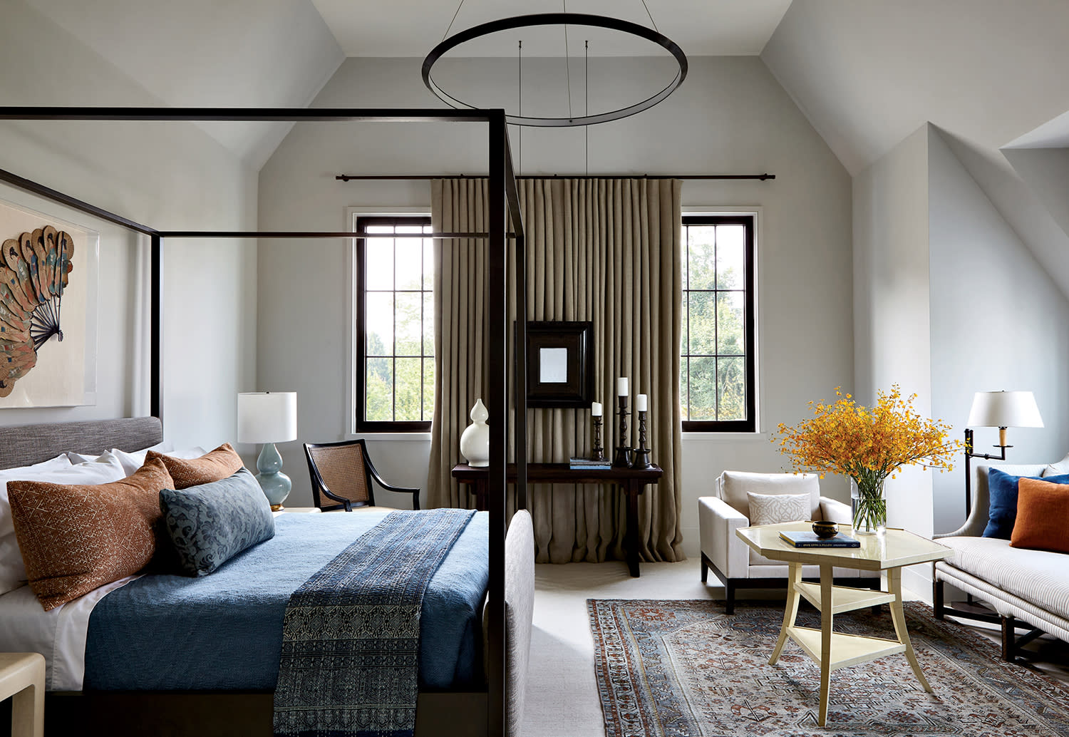 contemporary guest room with a canopy framed bed and pops of blue and orange throughout