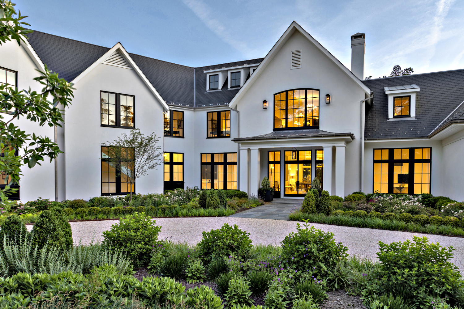 lush greenery lines a white home exterior