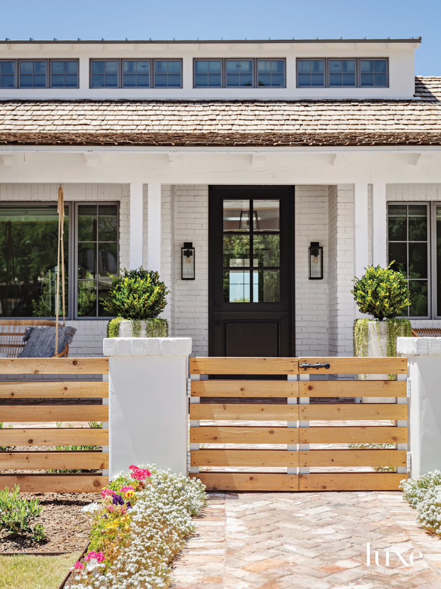 front door exterior with swinging chair and barn doors for a gate