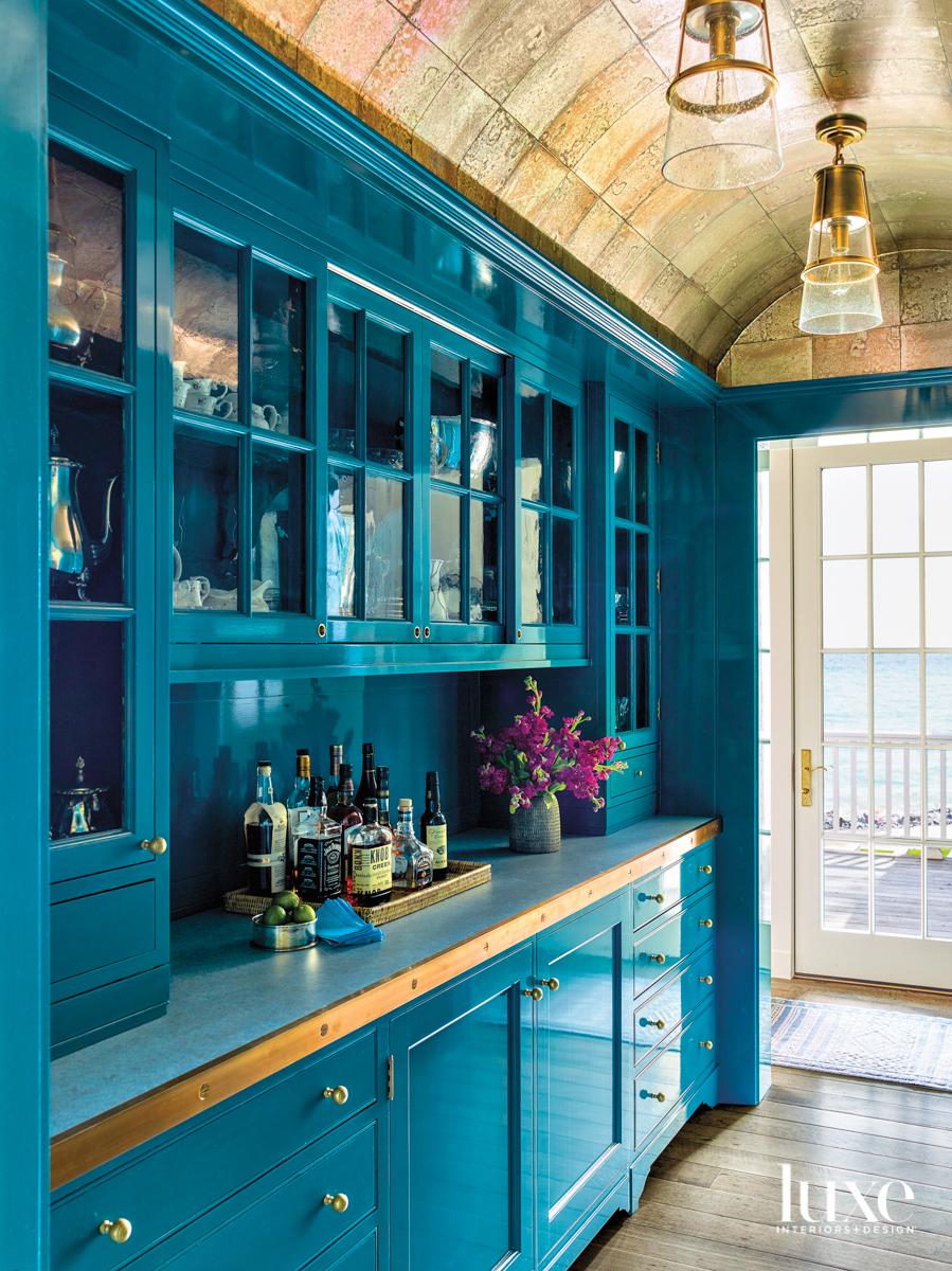 A teal cocktail pantry.