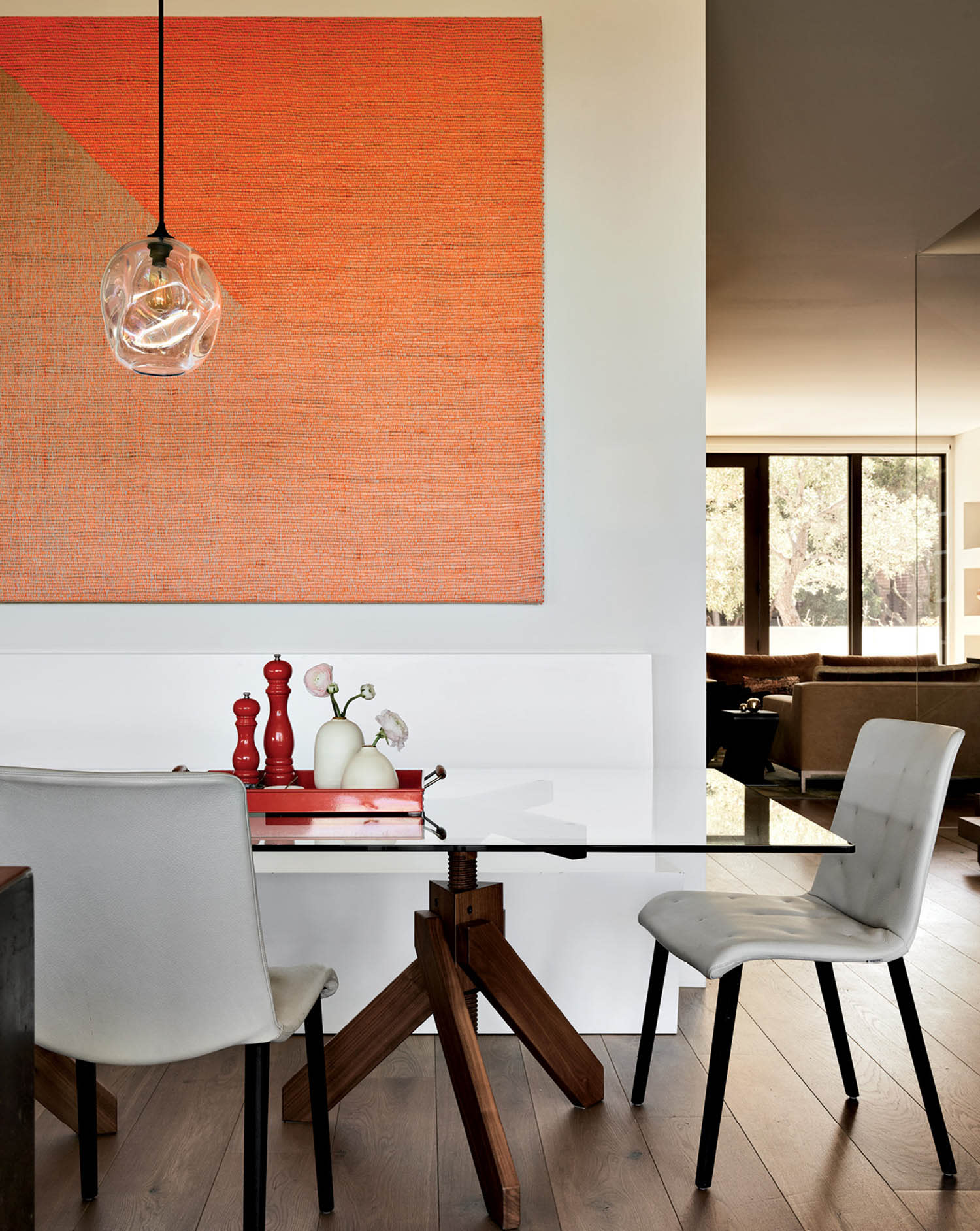 modern dining room with a large gradient orange artwork on the wall above the table