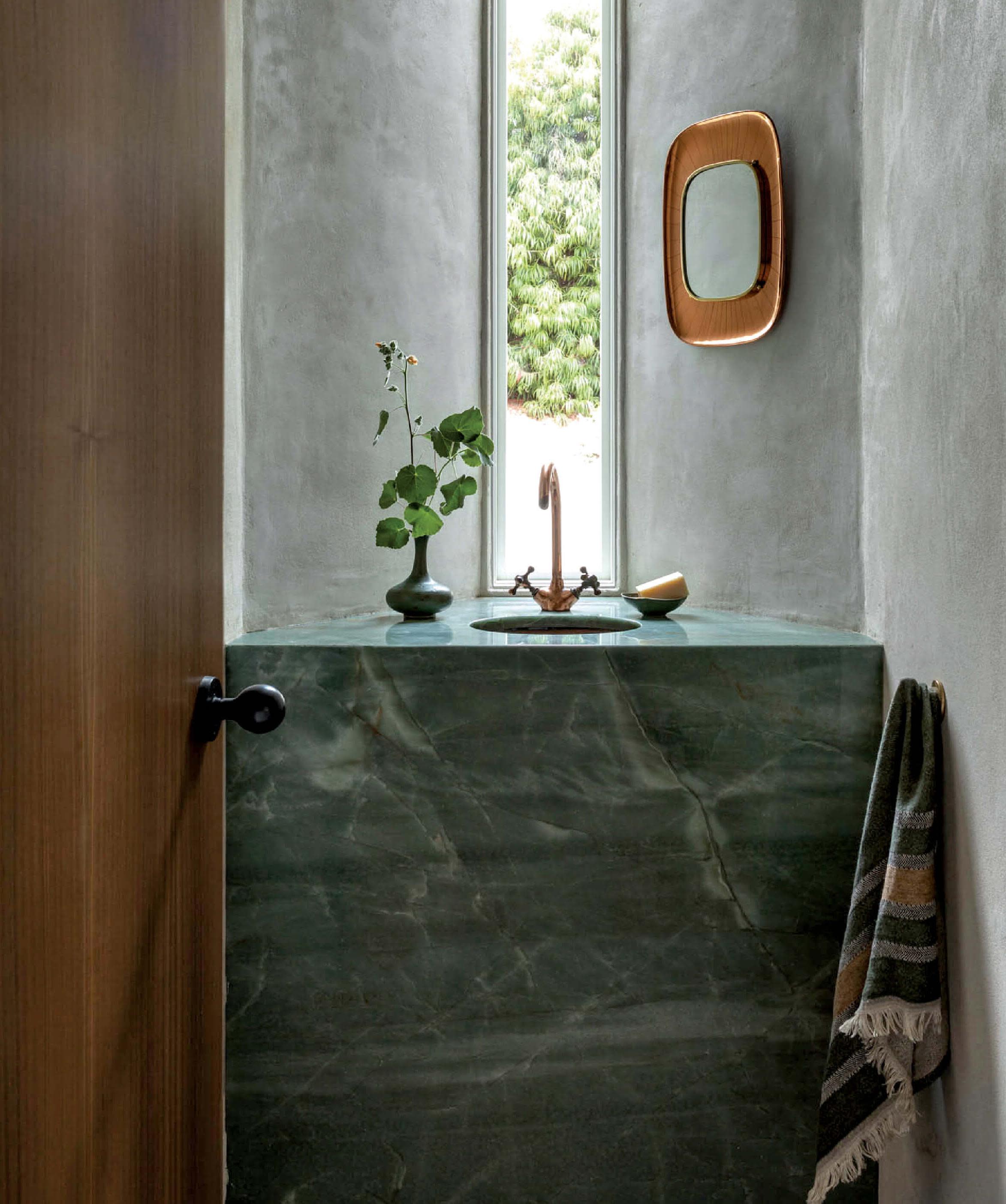 deep green marble sink in a powder room