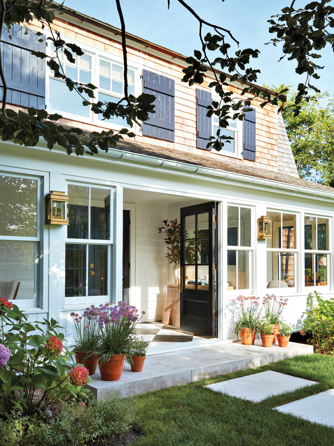 home exterior featuring array of potted plants and window panels