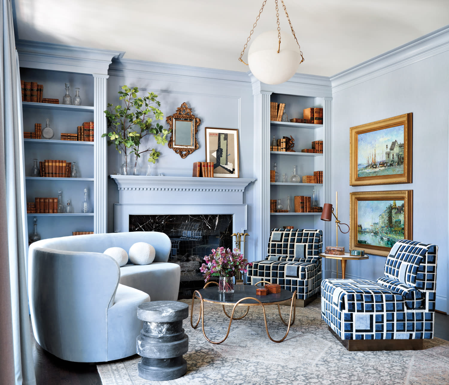 powder blue living room with geometric patterned chairs and curved sofa