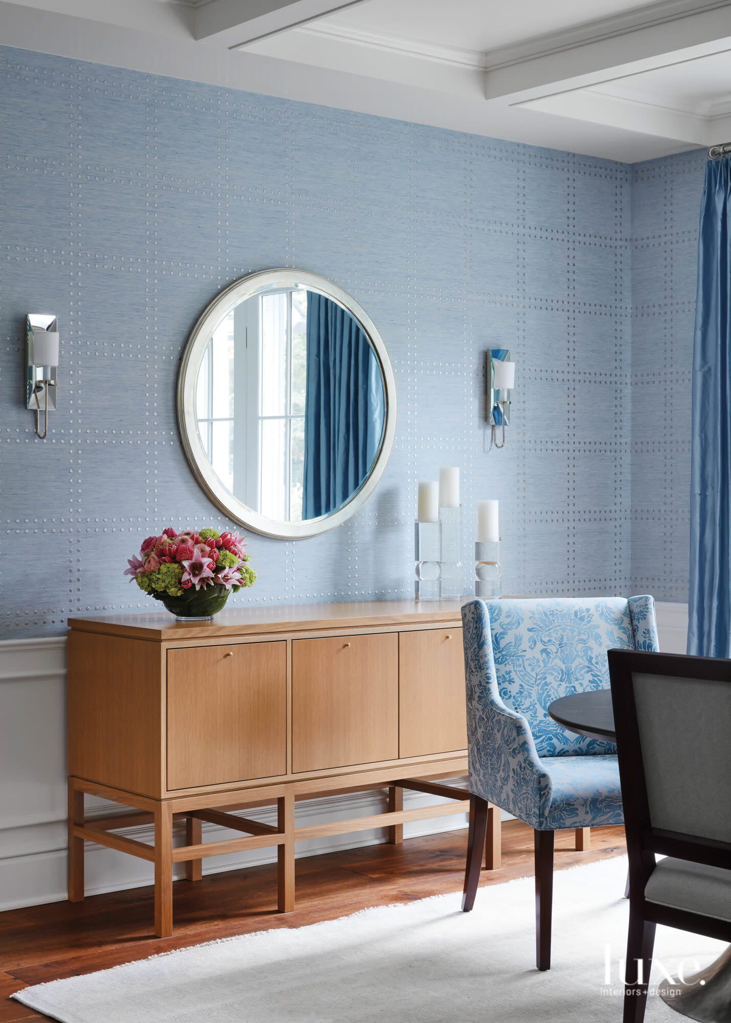 light blue walls in dining room with mirror above wood console