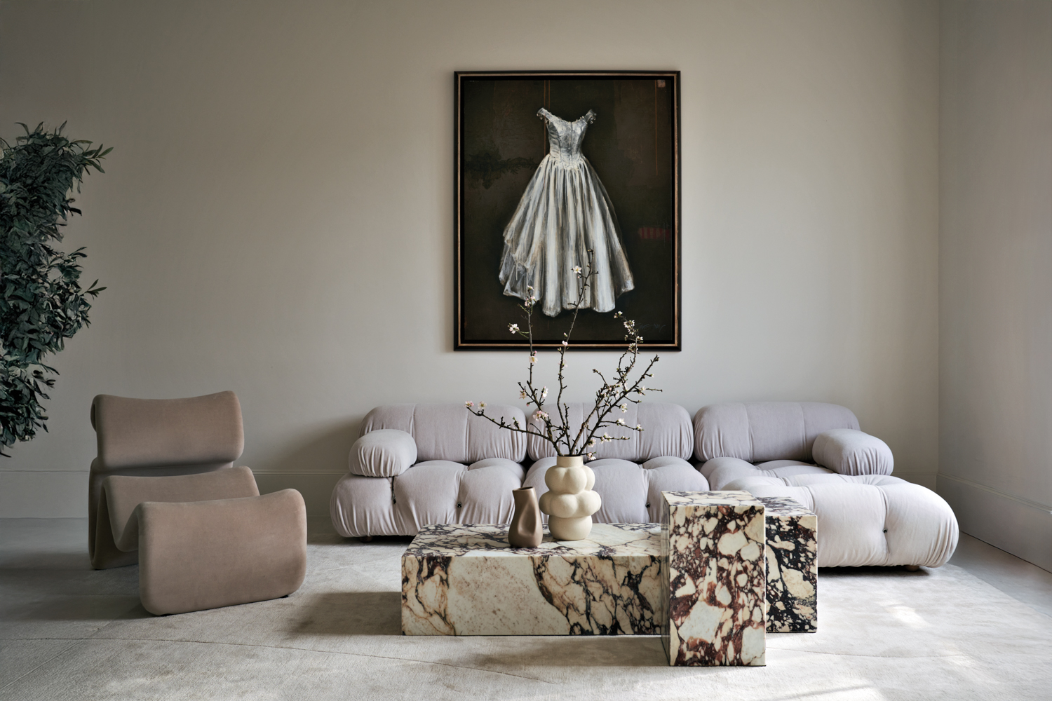 minimalist living room with a portrait of a white dress above a white sofa