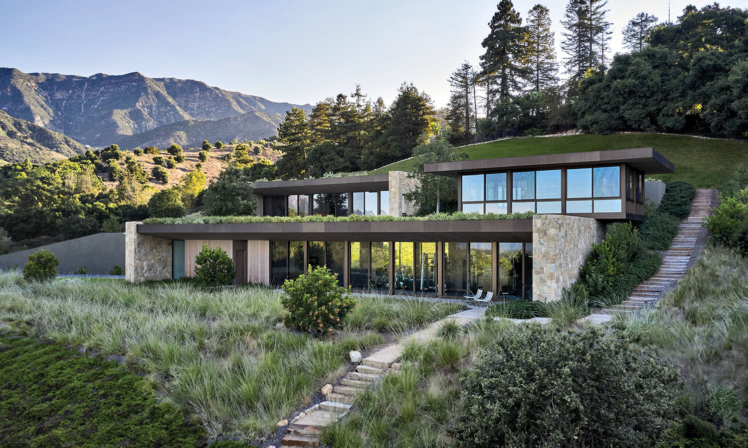 modern sculptural home exterior built into the hillside