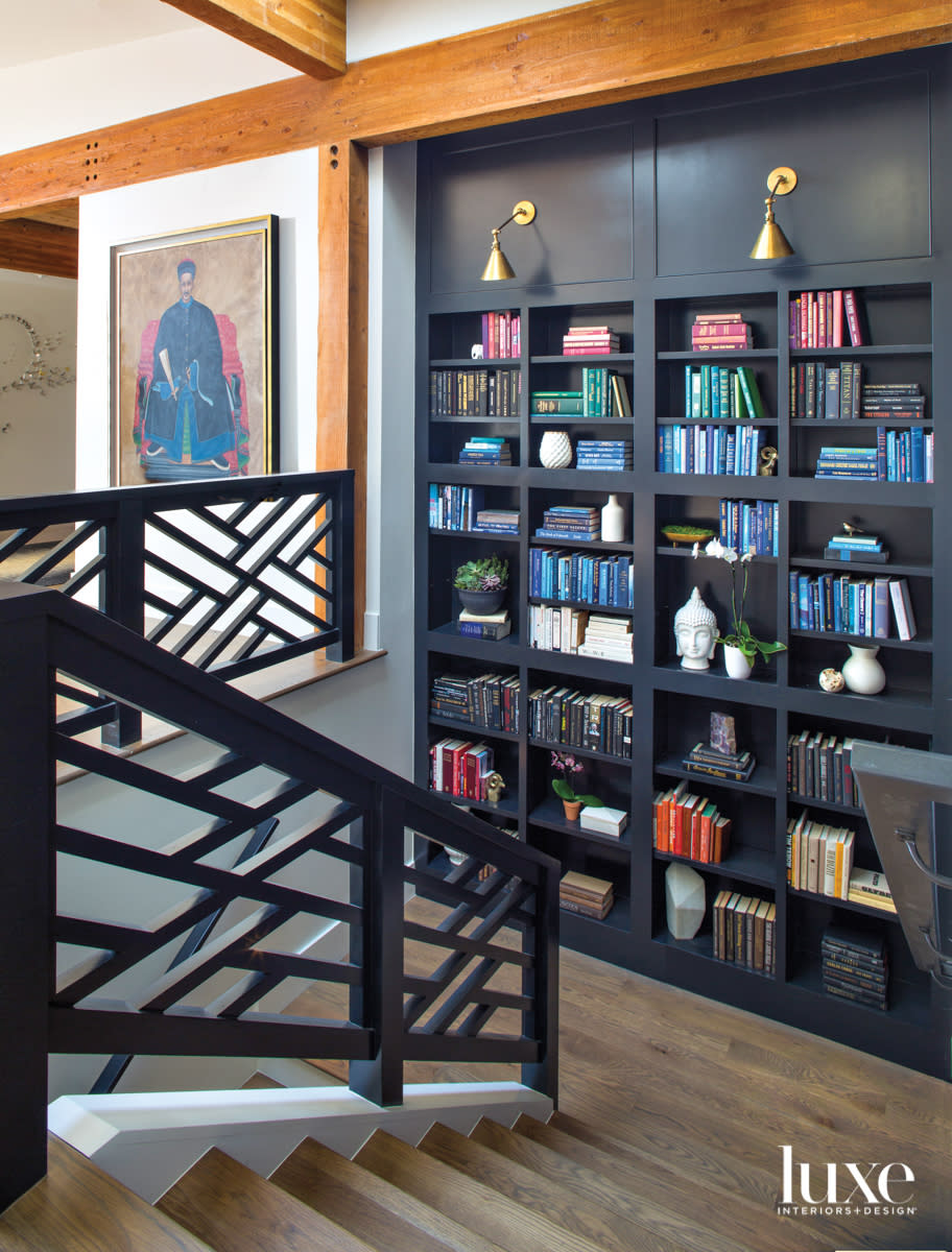 black stairway with chippendale-style railings and library