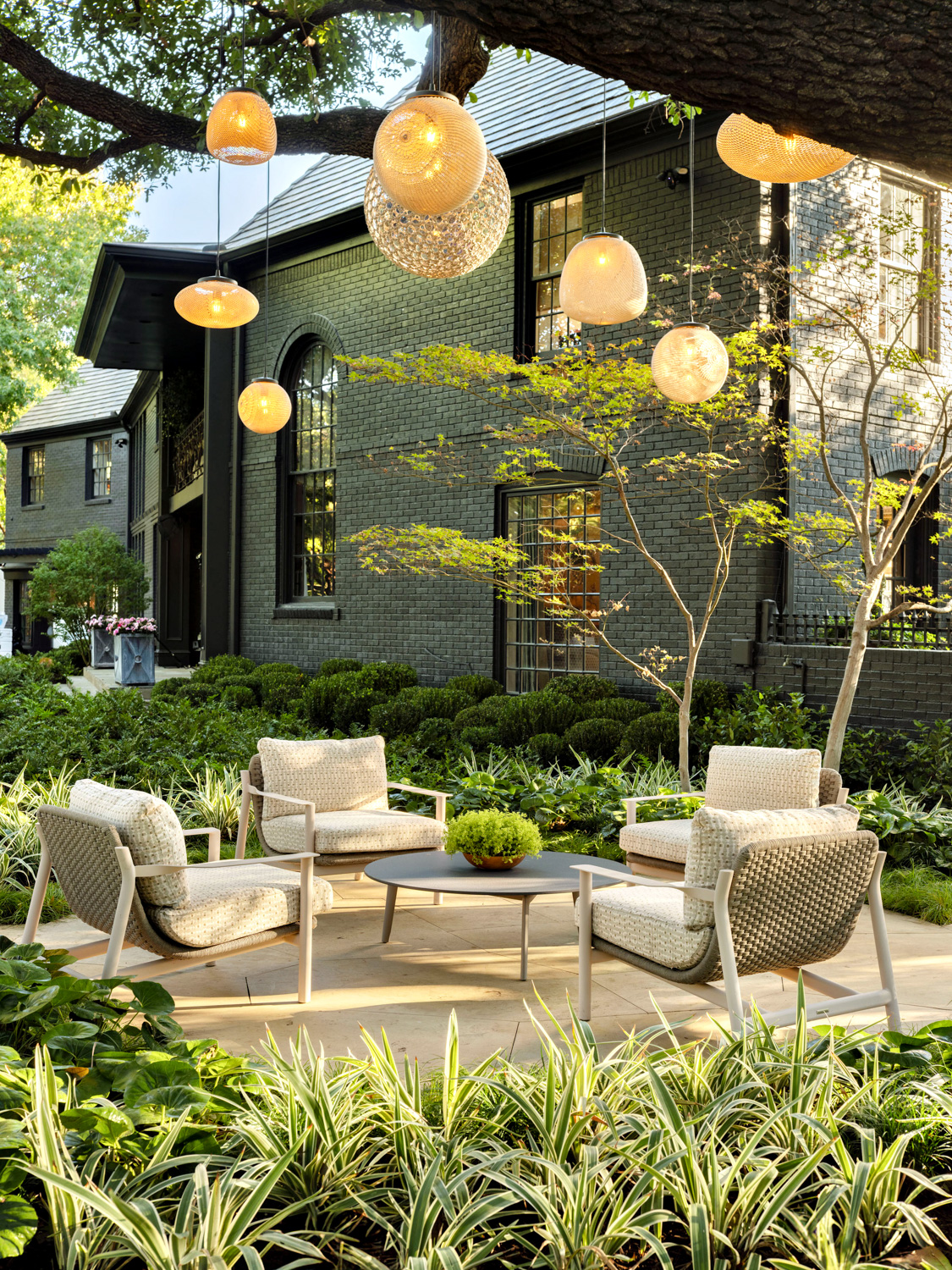 outdoor seating area with hanging lights off of a black exterior home