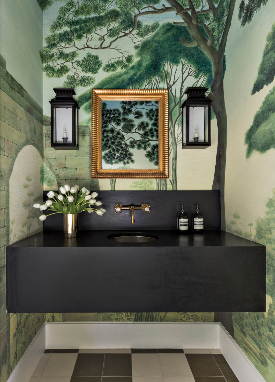 Nature-inspired wallpaper wraps powder bath with black vanity with an integrated sink.