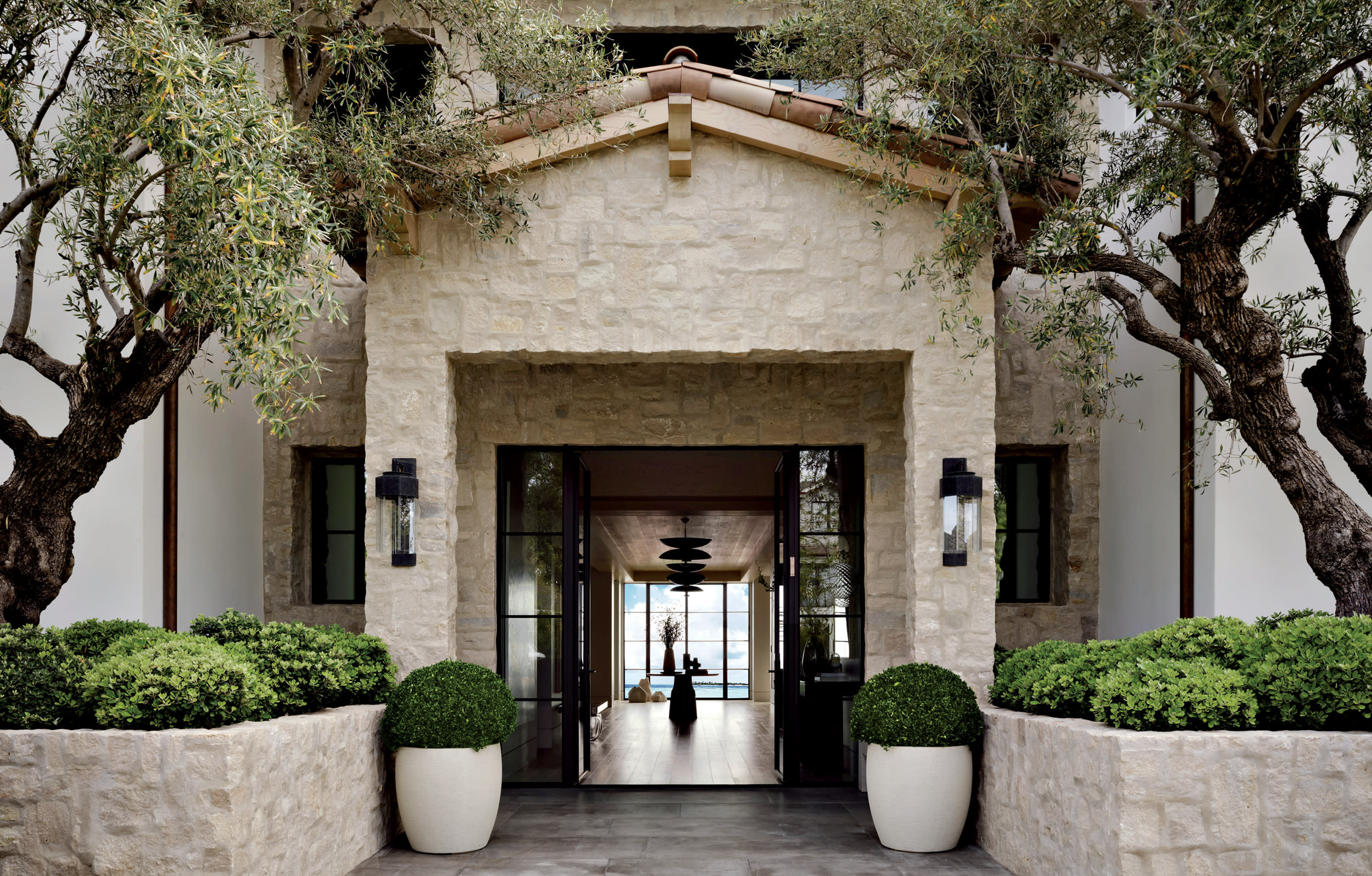 old-world style home exterior with limestone and white stucco walls