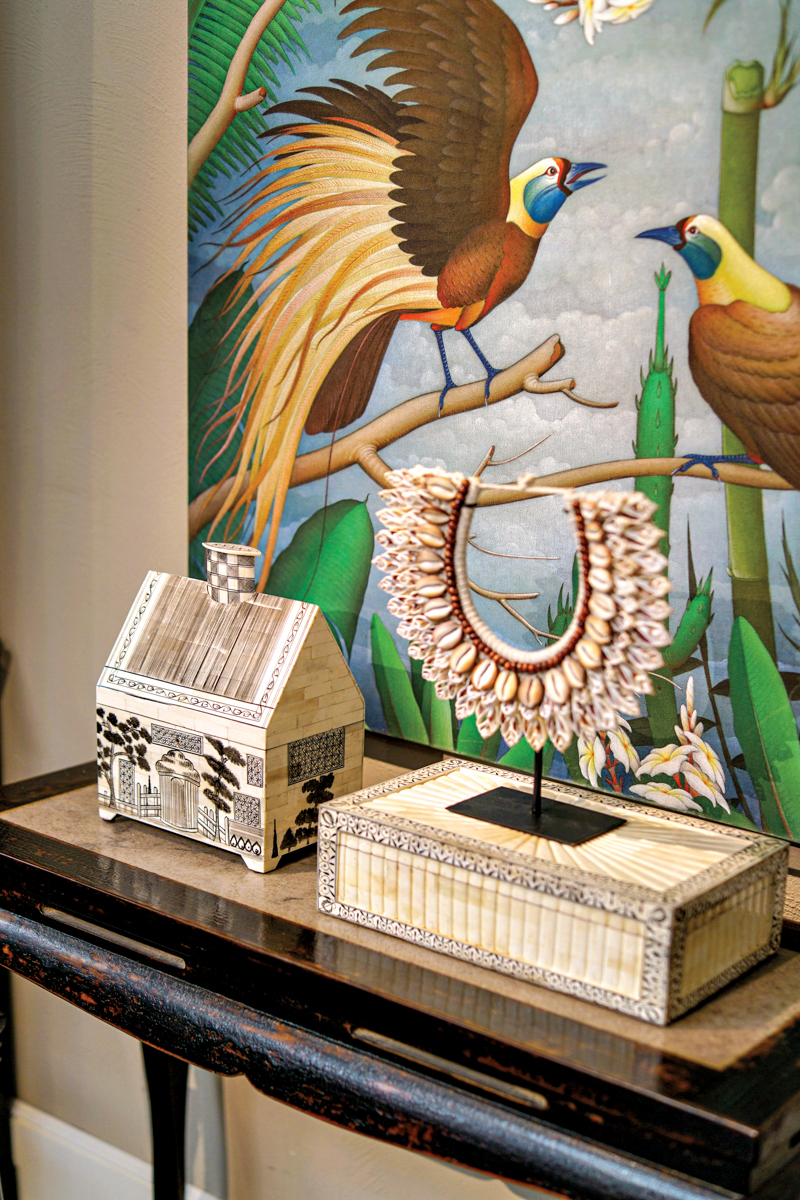 bird artwork behind a shell necklace
