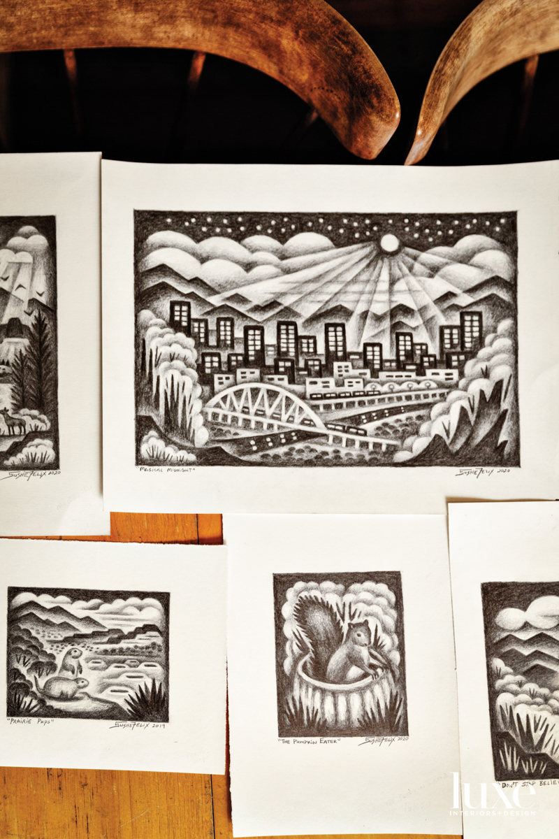 A series of black-and-white sketches are taped on a wall.