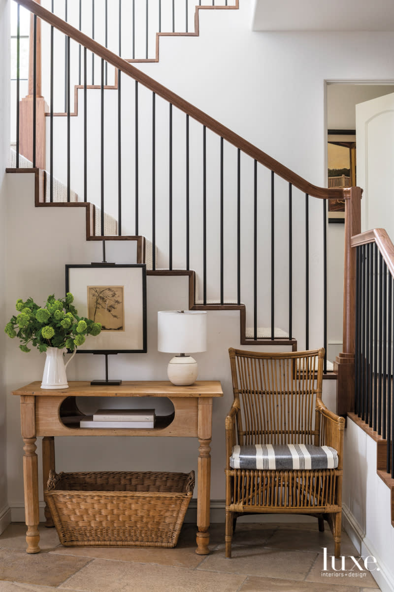 stairs and handrail featuring a console table and chair