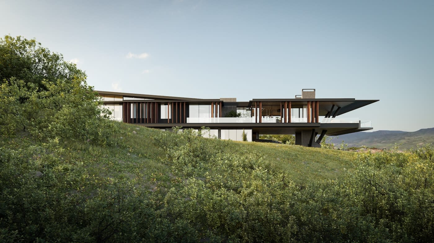 Modern house with large glass windows and wooden accents, perched on a grassy hillside. Surrounding greenery and distant mountains create a tranquil setting.