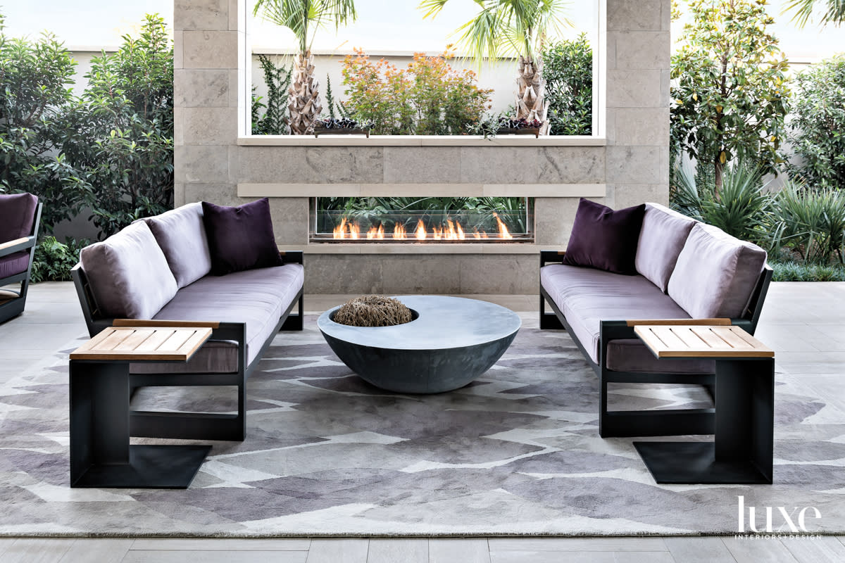 Outdoor terrace with a fireplace and luxurious seating.