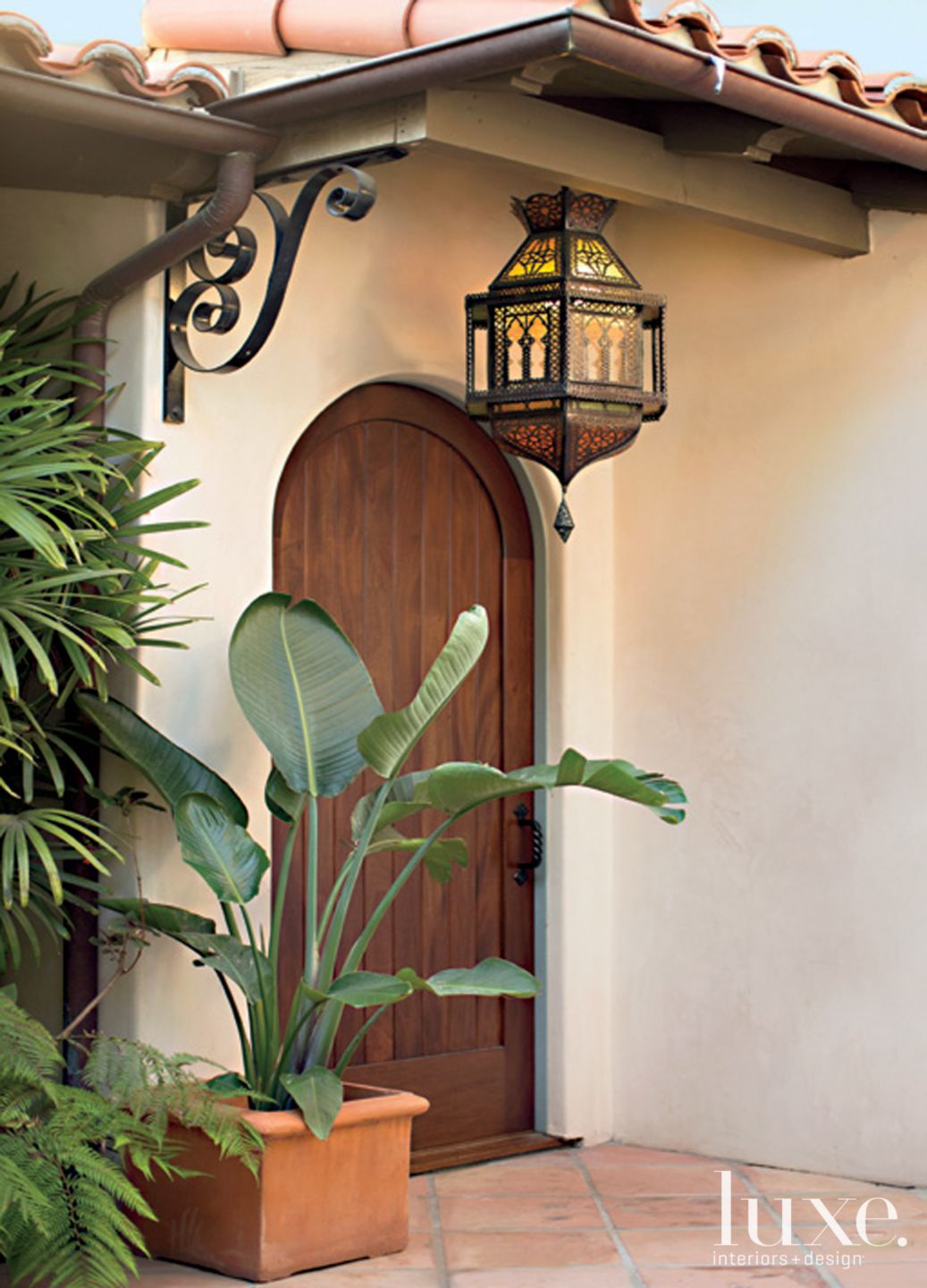 Brown Mediterranean Style Arched Front Door | LUXE Interiors + Design, image size:1037x1440