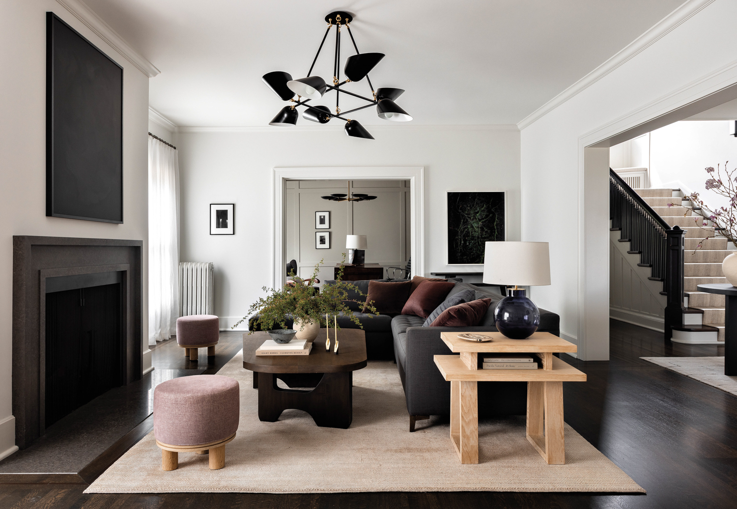 A sectional, coffee table and chandelier is centered in front of the fireplace in a Seattle Craftsman