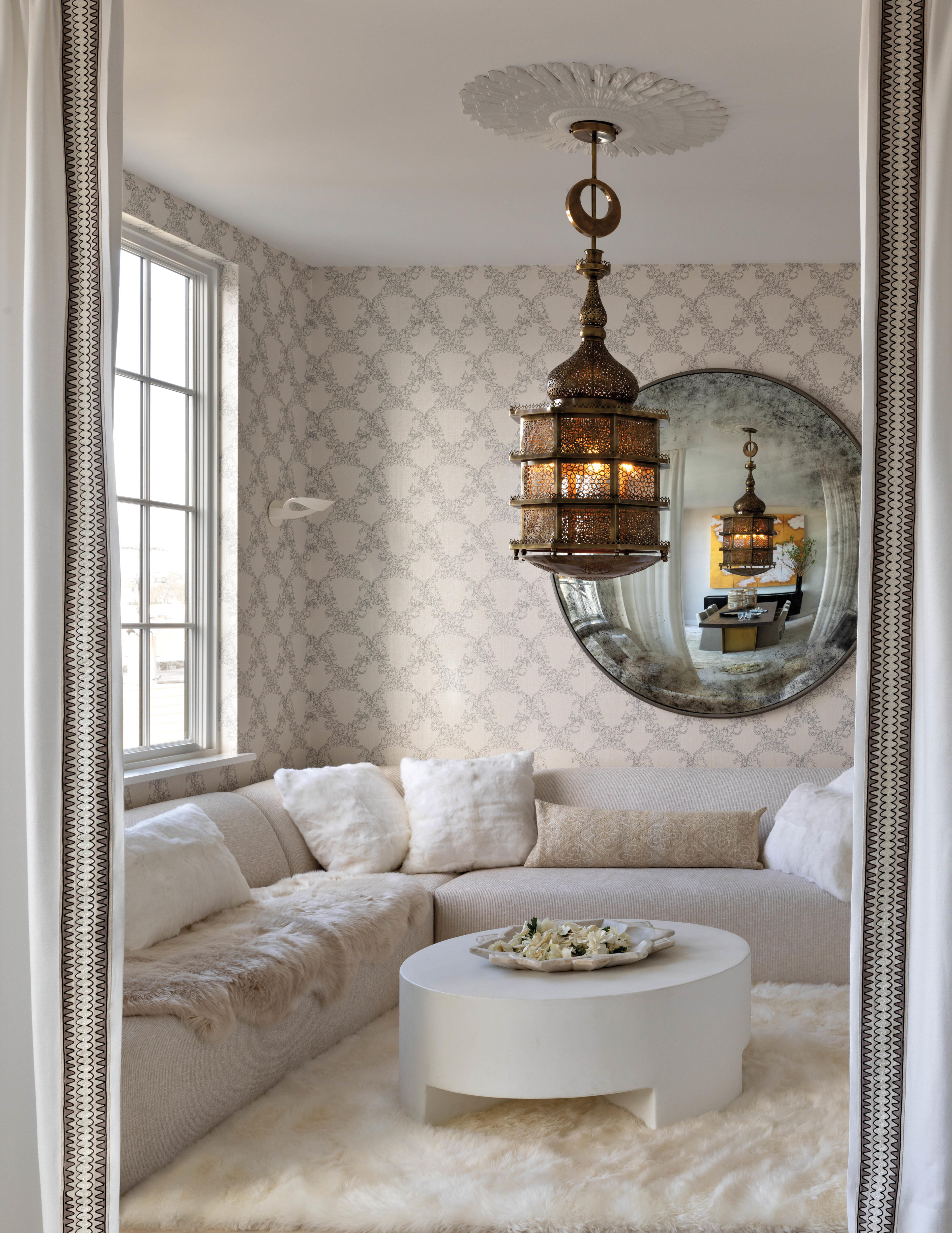 neutral Morocco-themed lounge with white shag rug and big RH mirror 