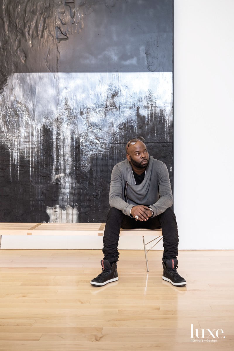 Dean sits in front of Number 74, a mixed-media piece on view in his exhibition "Recto/Verso: Duality of a Fragile Ego."