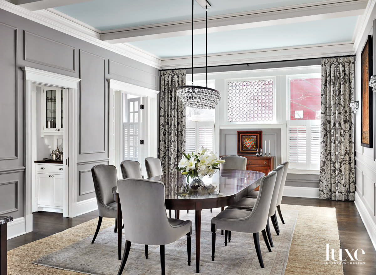 A gray dining room with gray-and-white floral curtains.