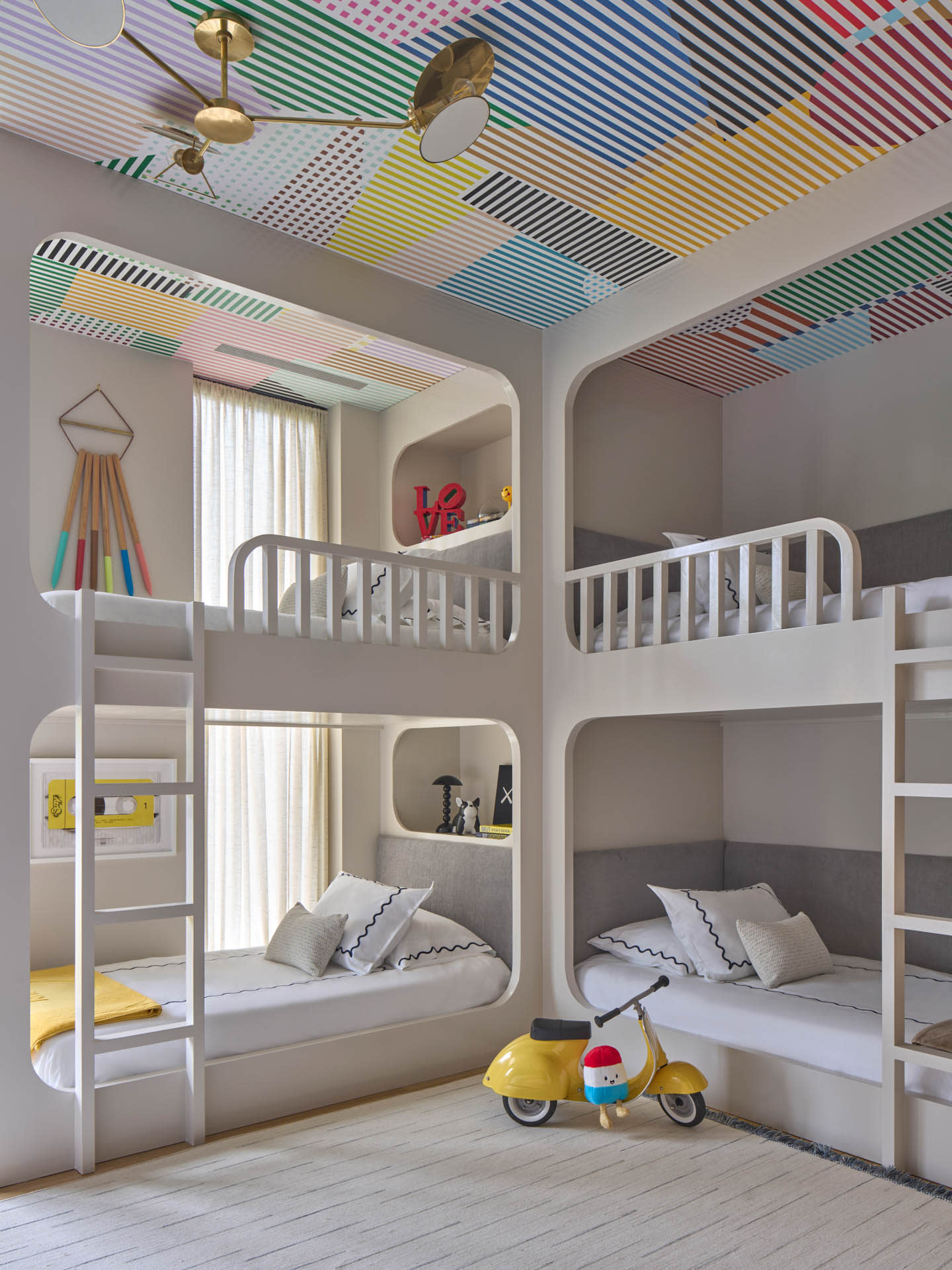 whimsical bunk room with a colorful wallcovering on the ceiling