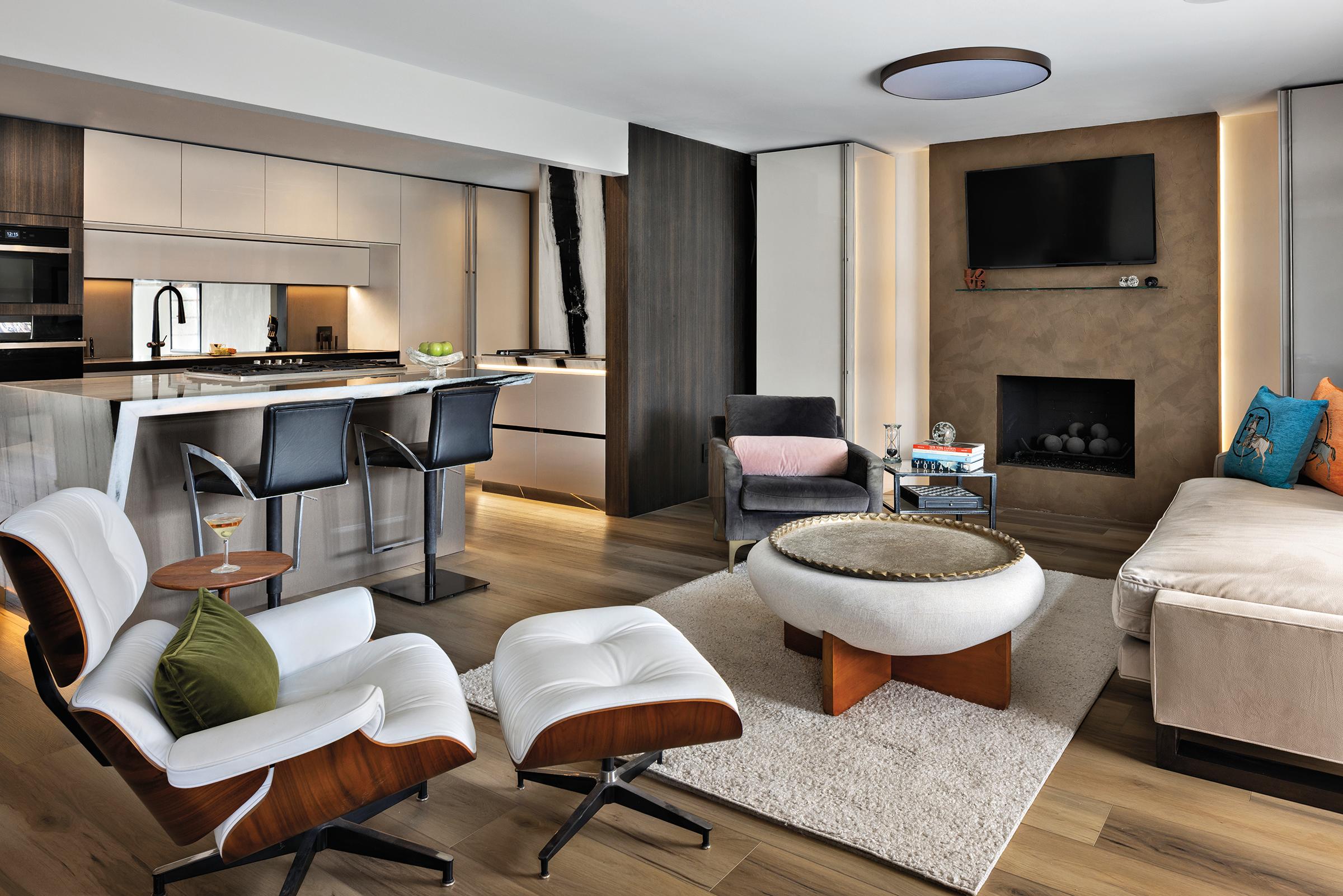 Wide view of the Pazzam Project kitchen by Pazzam Designs, showcasing a sculptural island, integrated cabinetry, and dramatic light-and-shadow contrast inspired by chiaroscuro principles.