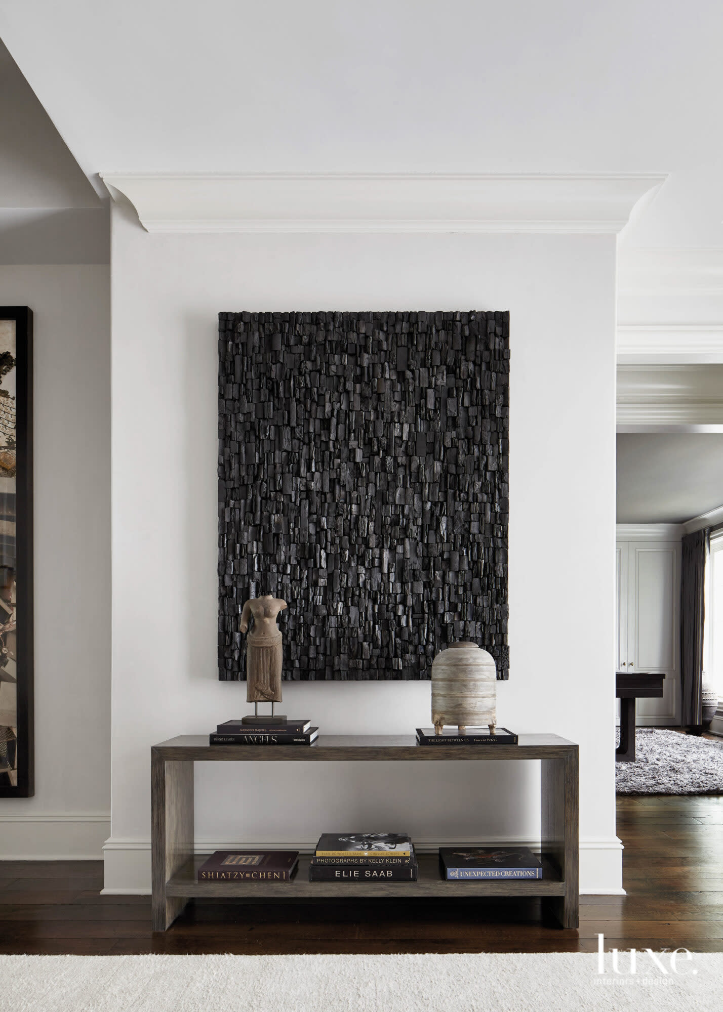 console table with black artwork in white room